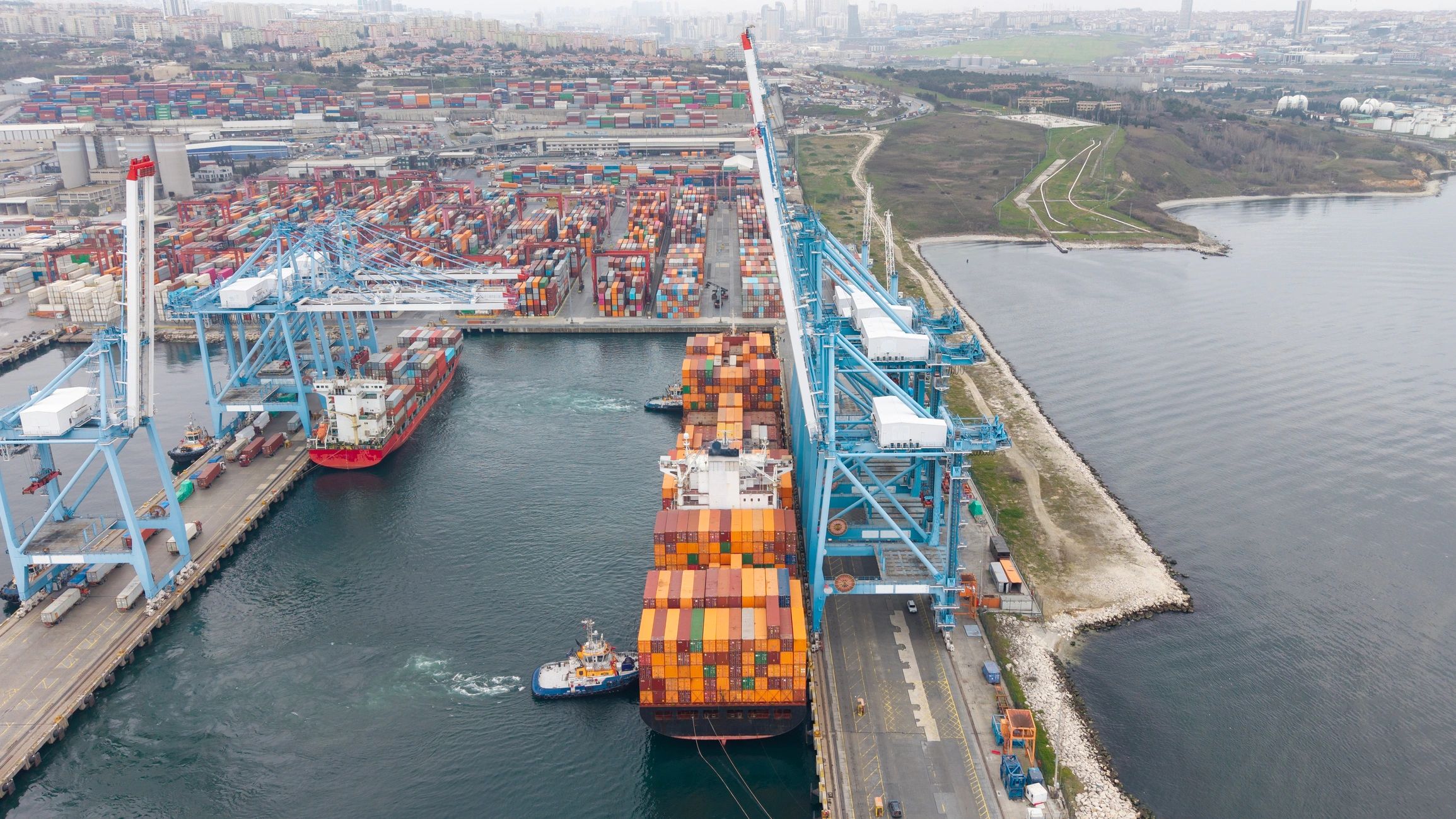 Cargo ships loading containers at a busy international shipping port