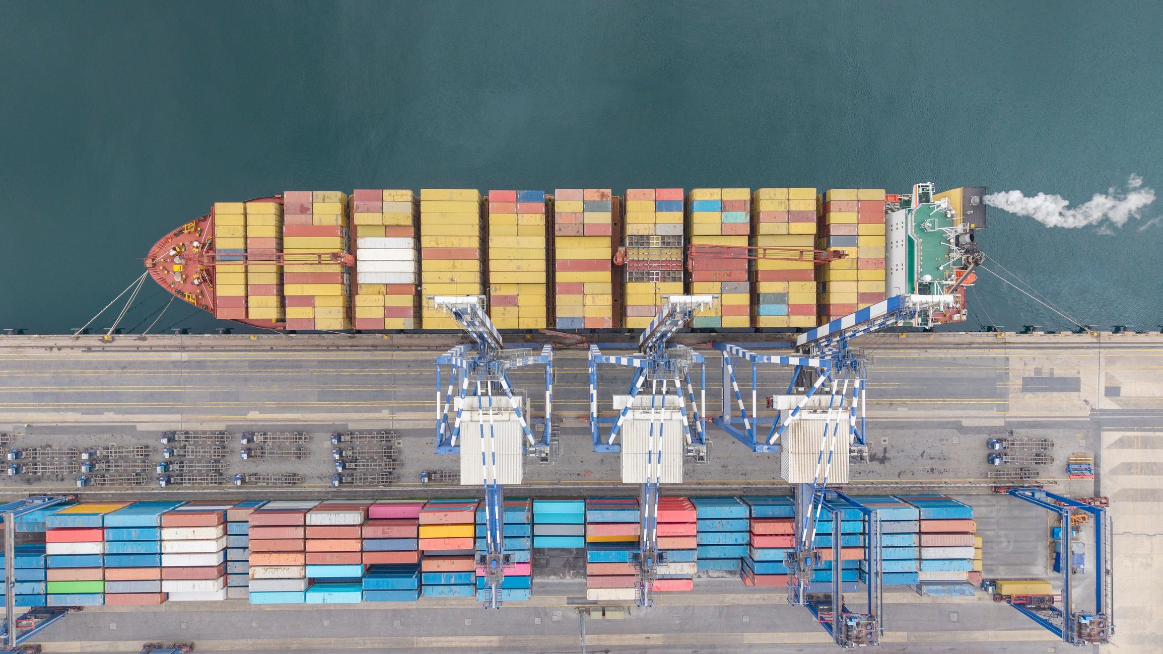 Container ship at commercial dock with cranes